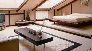 A modern bedroom with a skylight, a bed, a TV, and a dining table with bowls. - El Milano Real (Hoyos del Espino)