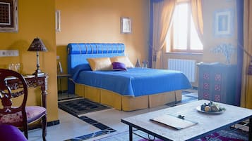 Un dormitorio con cama, escritorio, silla y ventana con cortinas.