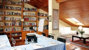 A cozy reading room with bookshelves, a whiteboard, and a table set for a meeting. - El Milano Real (Hoyos del Espino)