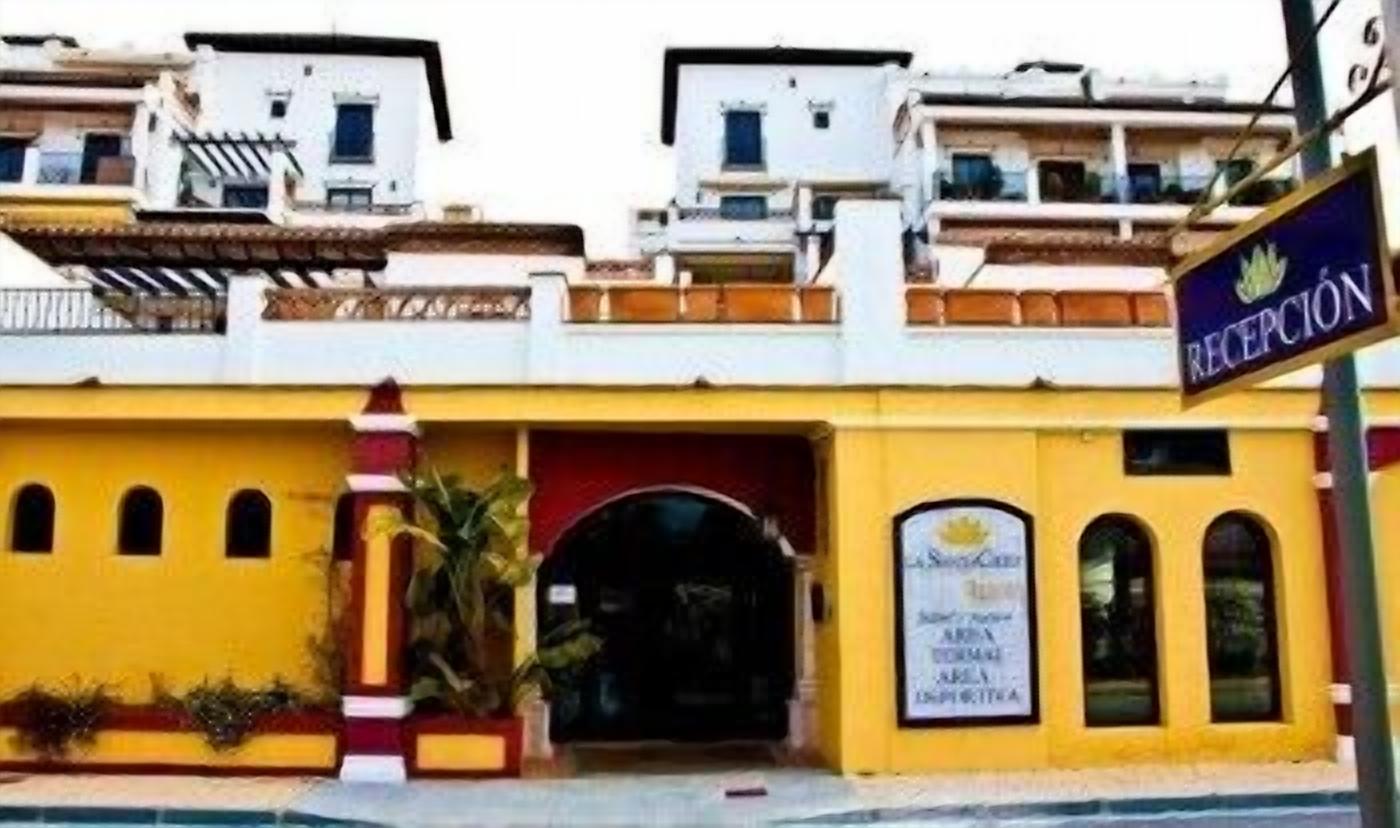 Un hotel con fachada amarilla, una zona de recepción y un cartel que indica que es un hotel 'RECEPTION'.