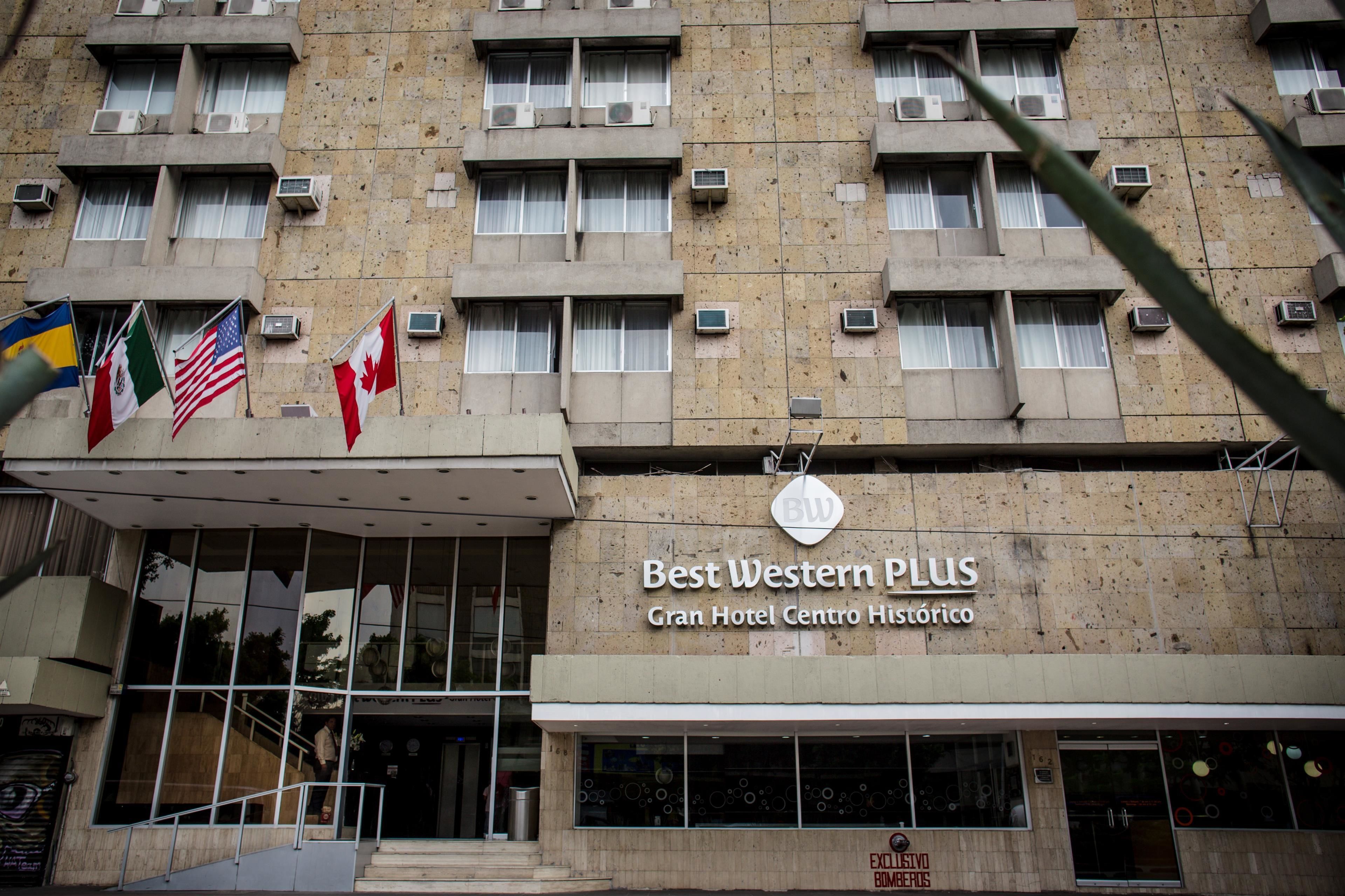 La façade du Best Western PLUS Gran Hotel Centro Histórico est ornée de nombreux drapeaux, de plusieurs unités de climatisation et d’une enseigne indiquant qu’il s’agit d’un bâtiment situé dans le centre historique.