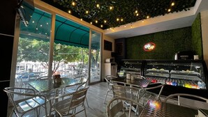 Un café con terraza, una máquina de café y vista a la calle.