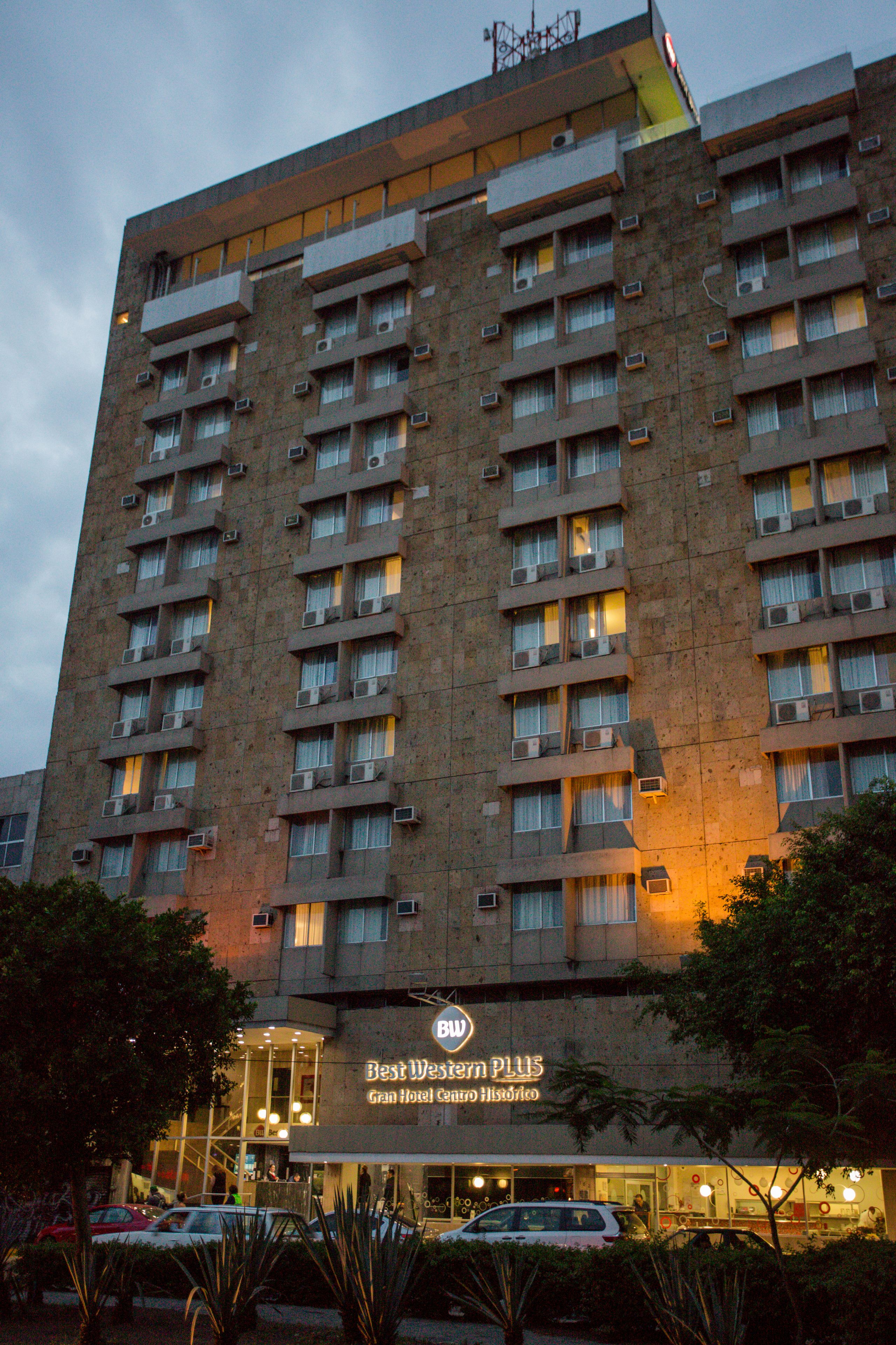 A multi-story hotel with balconies, air conditioning units, and a sign for 'Best Western PLUS Grand Hotel Centro Historico'.