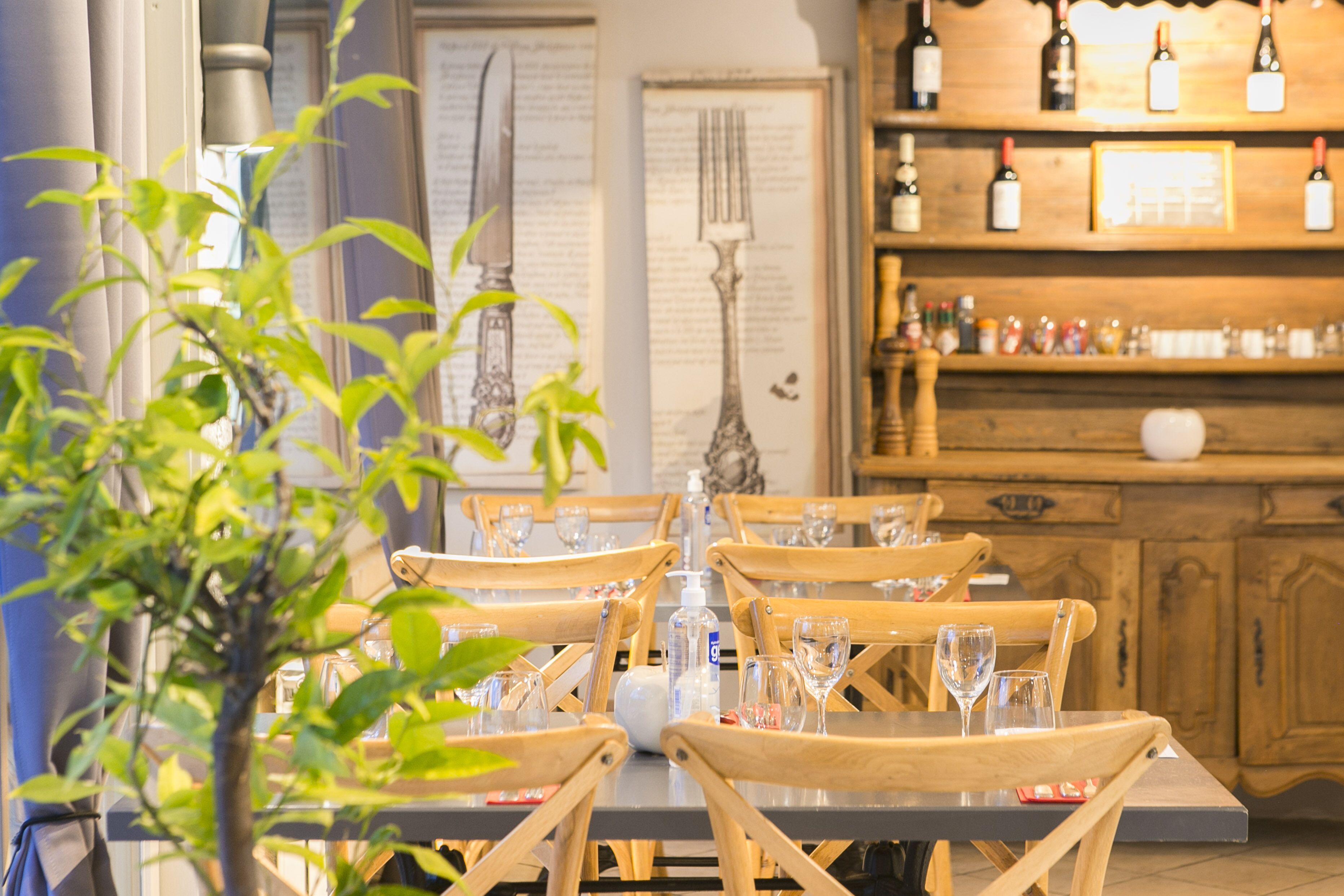 A dining area with wooden chairs and a table set for a meal, with a wine rack in the background.