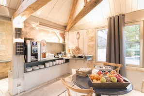 A breakfast area with a coffee machine, tea station, and fruit display. - Normandy Country Club (Saint-Martin-du-Vieux-Belleme)