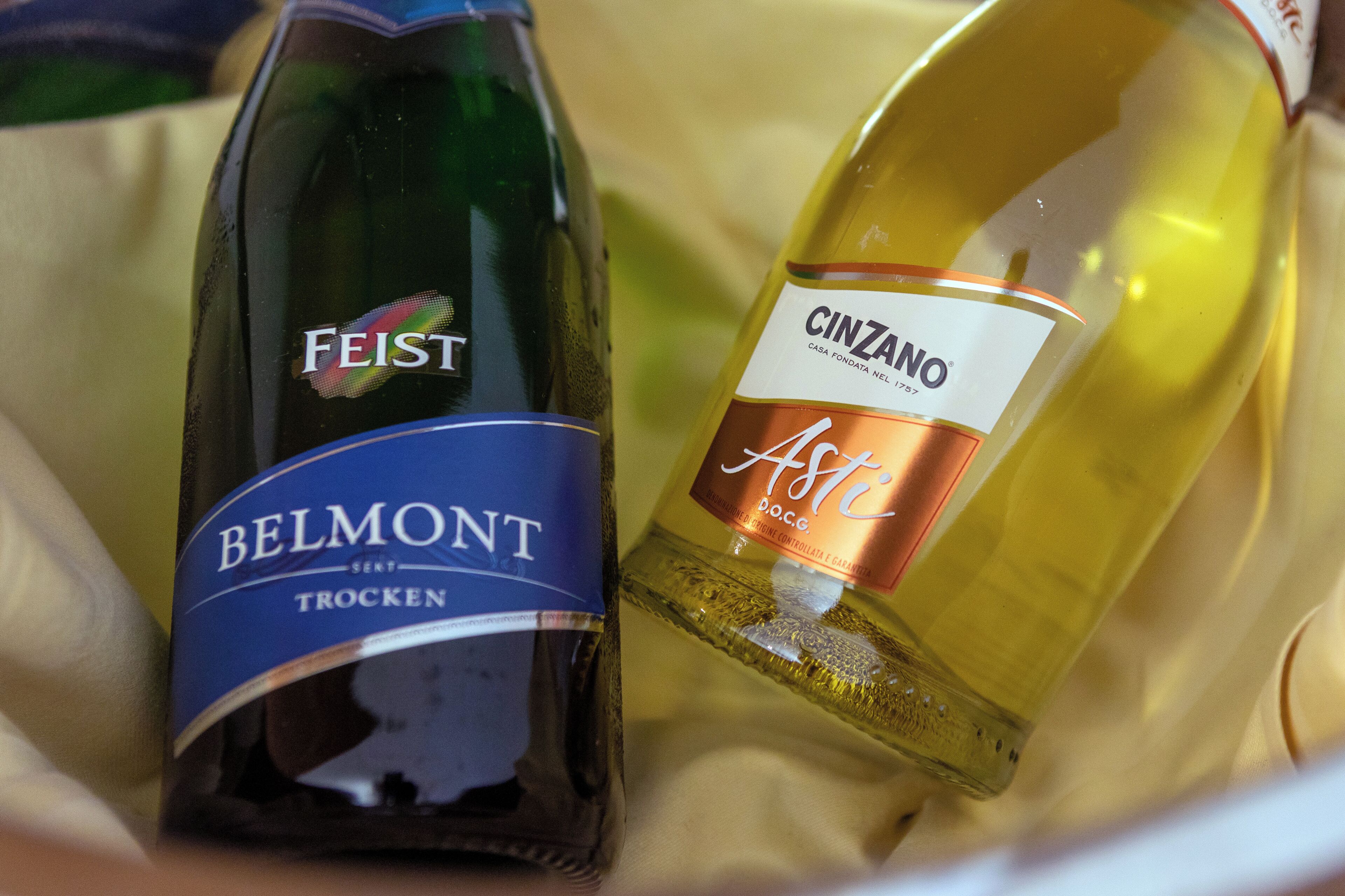 Two bottles of wine, one labeled 'BELMONT TROCKEN' and the other 'CINZANO ASTA DOC.G.'