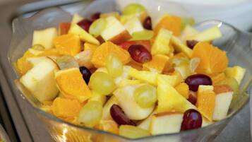 Een glazen schaal gevuld met een verscheidenheid aan fruit.