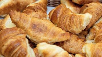 A basket filled with golden-brown croissants.