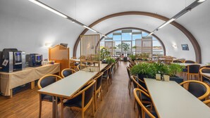 A spacious indoor dining area with wooden tables and chairs, a coffee station, and large windows allowing natural light. - Sun Parc Hotel (Ringsheim)