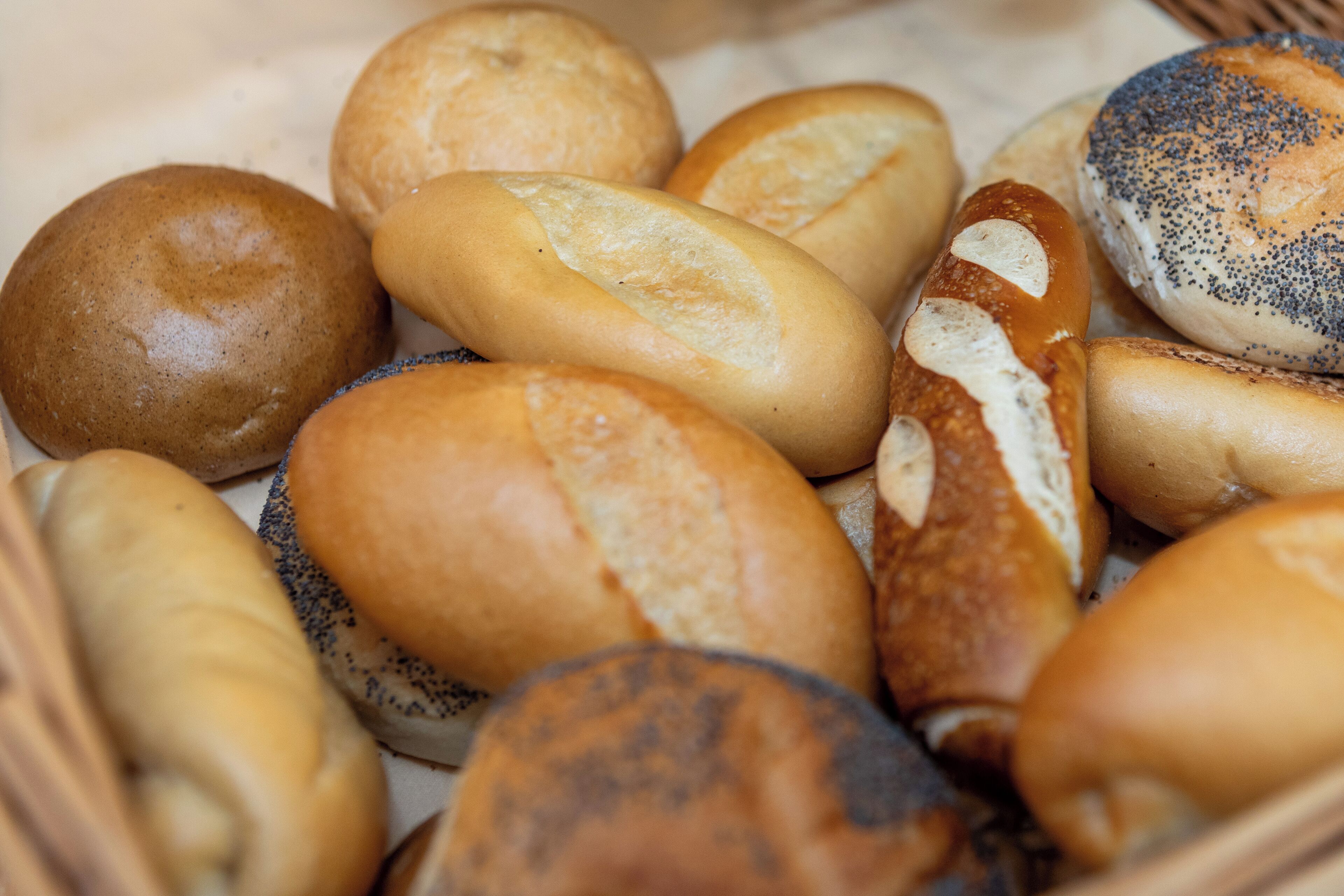A variety of bread rolls in a basket.