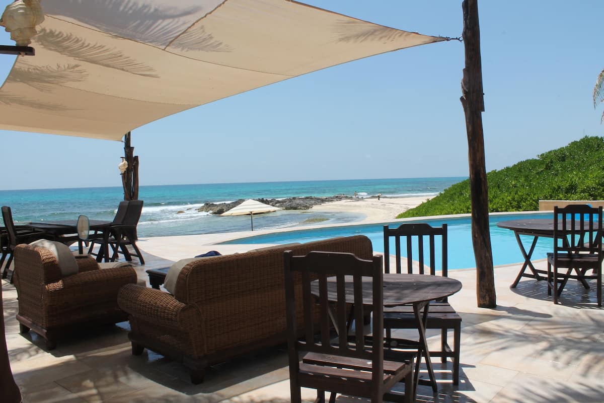An outdoor seating area with a view of the beach and ocean.
