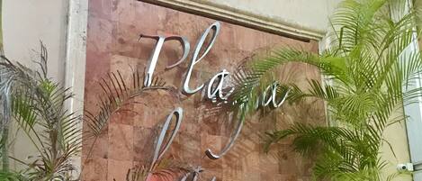 Pared de madera con la inscripción "Playa La Media Luna" grabada.