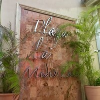Pared de madera con la inscripción "Playa La Media Luna" grabada.