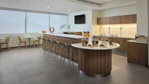 A modern kitchen with a central island, bar stools, and a large window. - Element by Marriott Arundel Mills BWI Airport (Hanover)