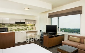 A hotel room with a kitchenette, a TV, a sofa, and a large window with a city view. - Element by Marriott Arundel Mills BWI Airport (Hanover)