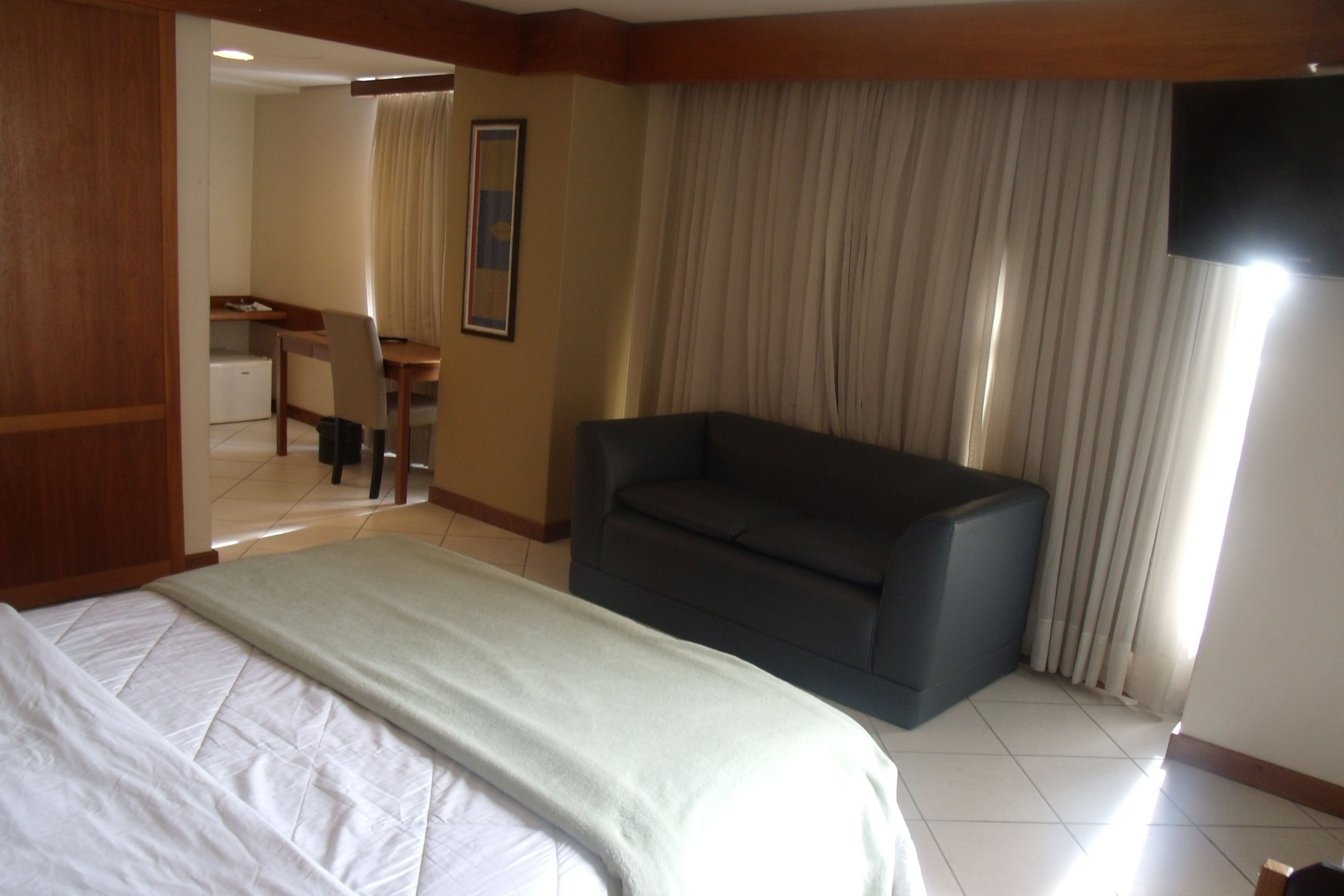 Een hotelkamer met een bed, een bank, een bureau en een televisietoestel.