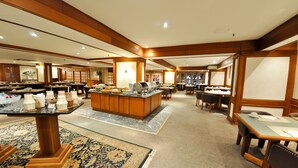 A spacious hotel lobby with multiple dining areas, a central reception desk, and a carpeted floor. - Continental Porto Alegre (Porto Alegre)