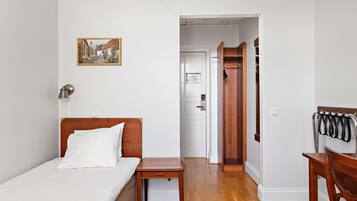 A bedroom with a bed, bedside table, and a door leading to a bathroom.