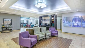 A spacious lobby with modern furniture, a large chandelier, and artwork on the walls.