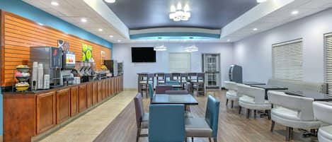 Un restaurante moderno con una barra larga, distintas opciones de asientos, incluyendo cabinas y mesas, y una variedad de dispensadores de comida y bebida.