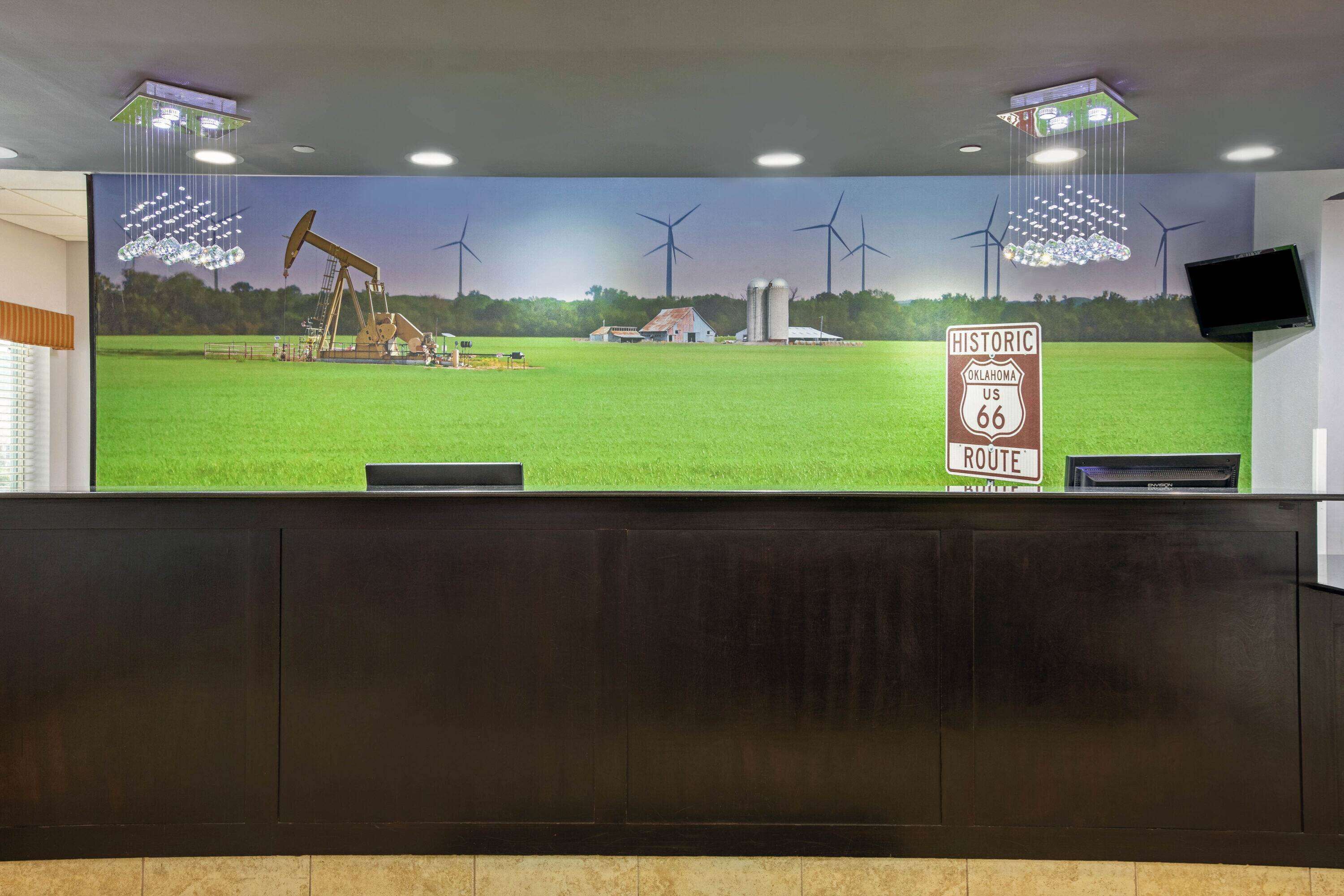 A reception area with a large mural of a green field, wind turbines, and an oil pumpjack. A sign reads "Historic Route 66."