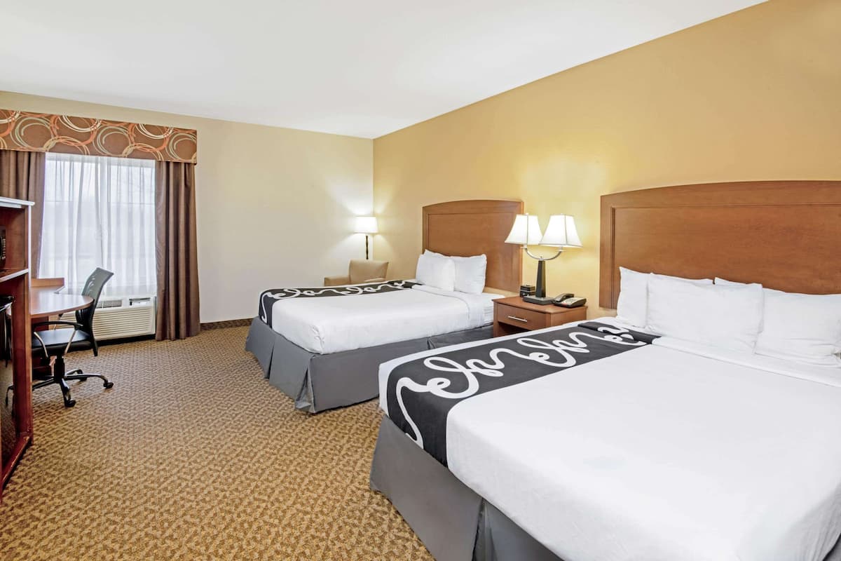 Una habitación de hotel con dos camas, un escritorio y una silla.