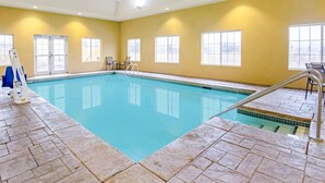 An indoor swimming pool with clear blue water, tiled walls, and a yellow color scheme.