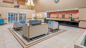 A lobby with a reception desk, seating area, and a large window.