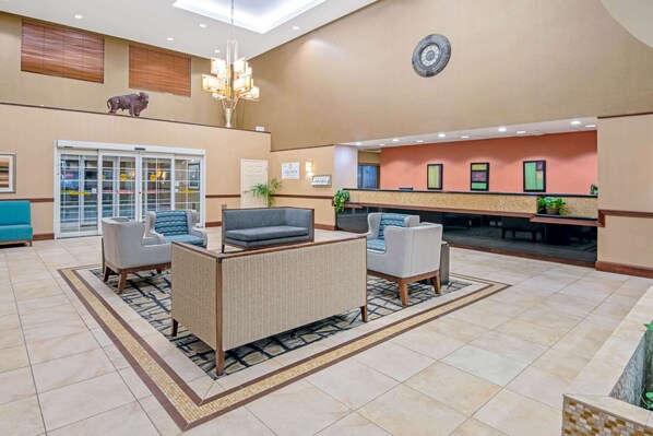 A lobby with a reception desk, seating area, and a large window. - La Quinta Inn & Suites by Wyndham Lawton / Fort Sill (Lawton)