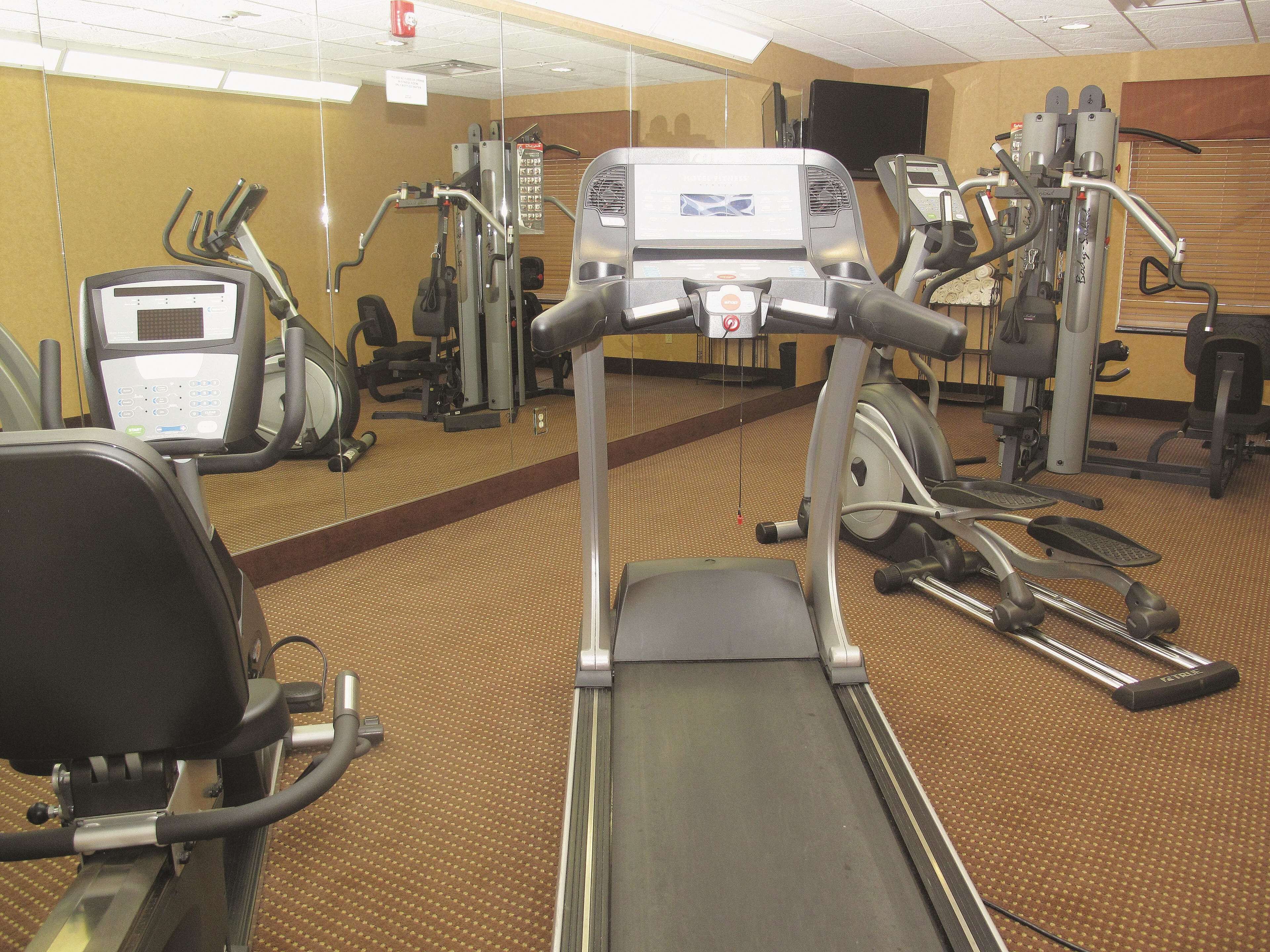 A gym with various exercise machines, including treadmills and elliptical trainers.