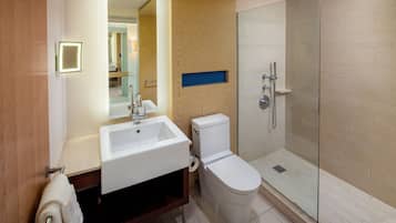 A modern bathroom with a sink, toilet, and glass-enclosed shower.