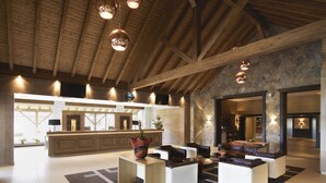 A spacious lobby with a reception desk, seating area, and a stone accent wall. - Ana Hotels Sport Poiana Brasov (Brasov)