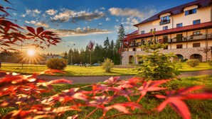 A hotel with a stone facade, multiple balconies, and a view of the surrounding landscape. - Ana Hotels Sport Poiana Brasov (Brasov)