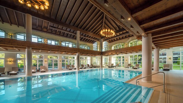 An indoor swimming pool with clear blue water, wooden beams, and large windows. - Ana Hotels Sport Poiana Brasov (Brasov)