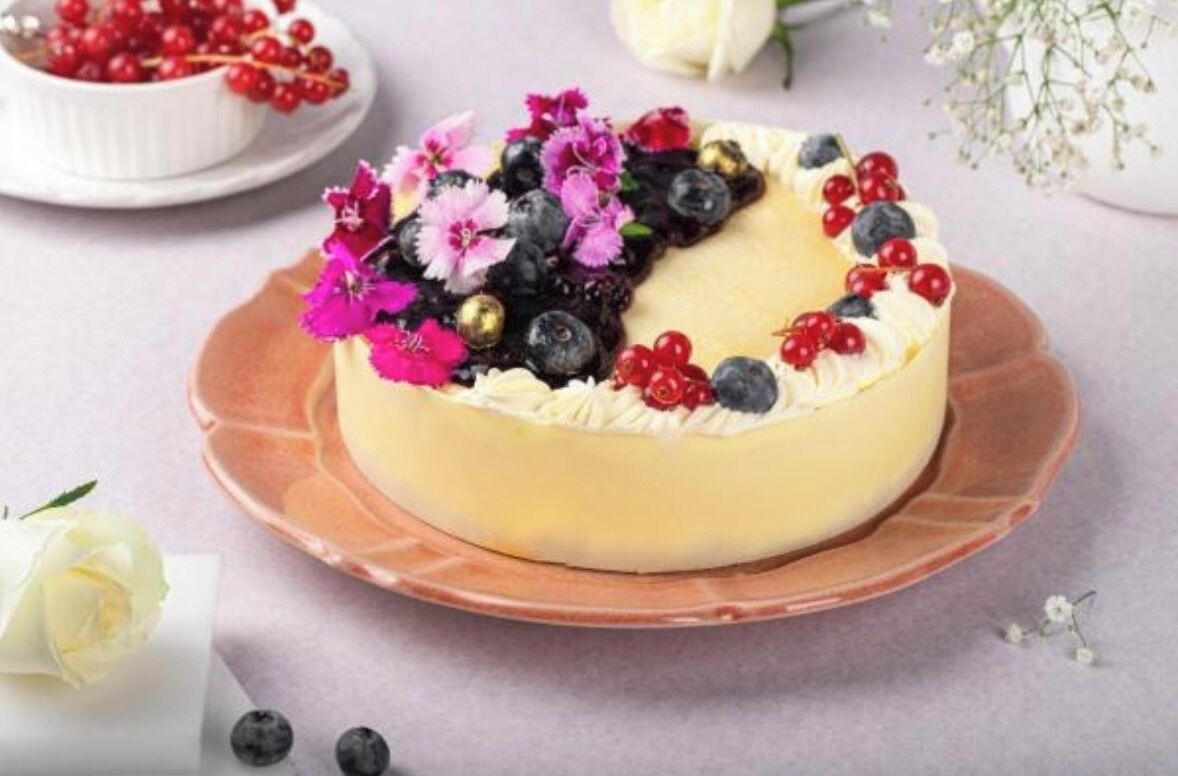 Taart met fruit en bloemen op een bord.