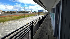 A covered walkway with a view of a road and buildings in the distance. - Briarwood Motel Near Valdosta University I 75 (Valdosta)
