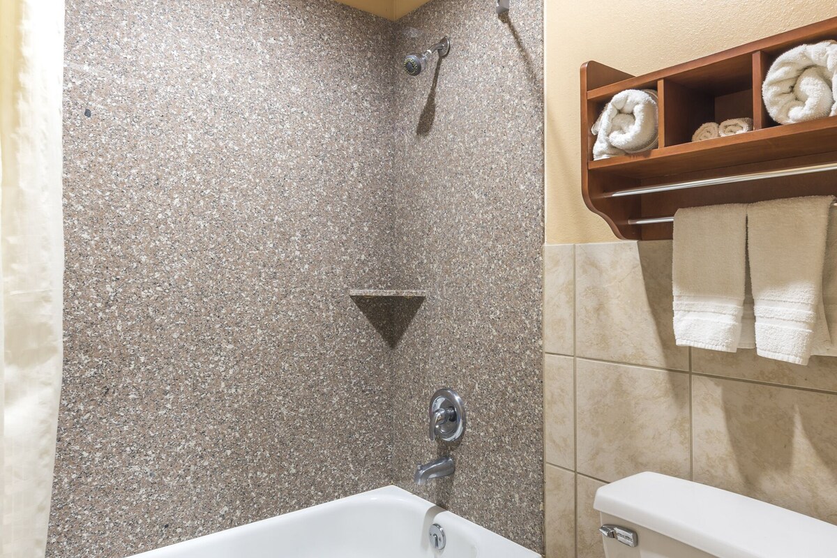 A bathroom with a bathtub, toilet, and a shower.