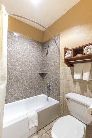 Un baño con bañera, inodoro y ducha.