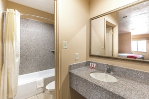 Un baño con bañera, inodoro y lavamanos.