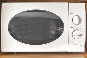 Un microondas con pantalla digital y perillas de control.