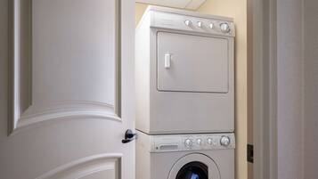 A stacked washer and dryer unit in a hallway.