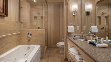 A modern bathroom with a bathtub, a shower, a toilet, and a vanity with a sink and mirrors.
