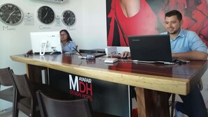 Un comptoir d’accueil d’hôtel avec des horloges indiquant l’heure à Miami, à Cancun et à Madrid.