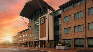 Un hôtel moderne, reconnaissable à son grand panneau « AC Hotels Marriott », à ses larges fenêtres et à sa façade en briques.