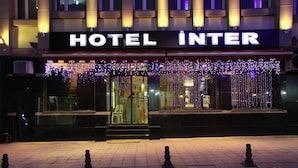 L’entrée d’un hôtel, avec une enseigne indiquant « HÔTEL INTER ».