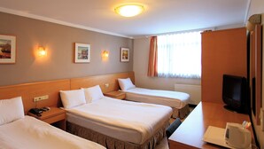 Une chambre d’hôtel avec deux lits, une télévision et une machine à café.
