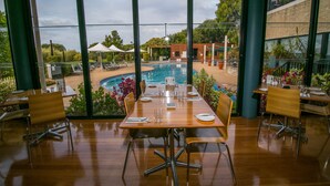 A dining area with a view of an outdoor pool and garden. - Club Wyndham Dunsborough, Trademark Collection by Wyndham (Marybrook)
