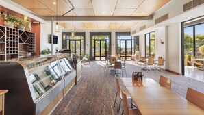 A modern hotel lobby with a central counter, seating area, and large windows offering views. - Club Wyndham Dunsborough, Trademark Collection by Wyndham (Marybrook)