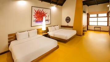Quarto de hotel com duas camas, uma janela grande e obras de arte nas paredes.