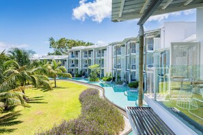 Un resort con edificios de varios pisos, una piscina y palmeras.
